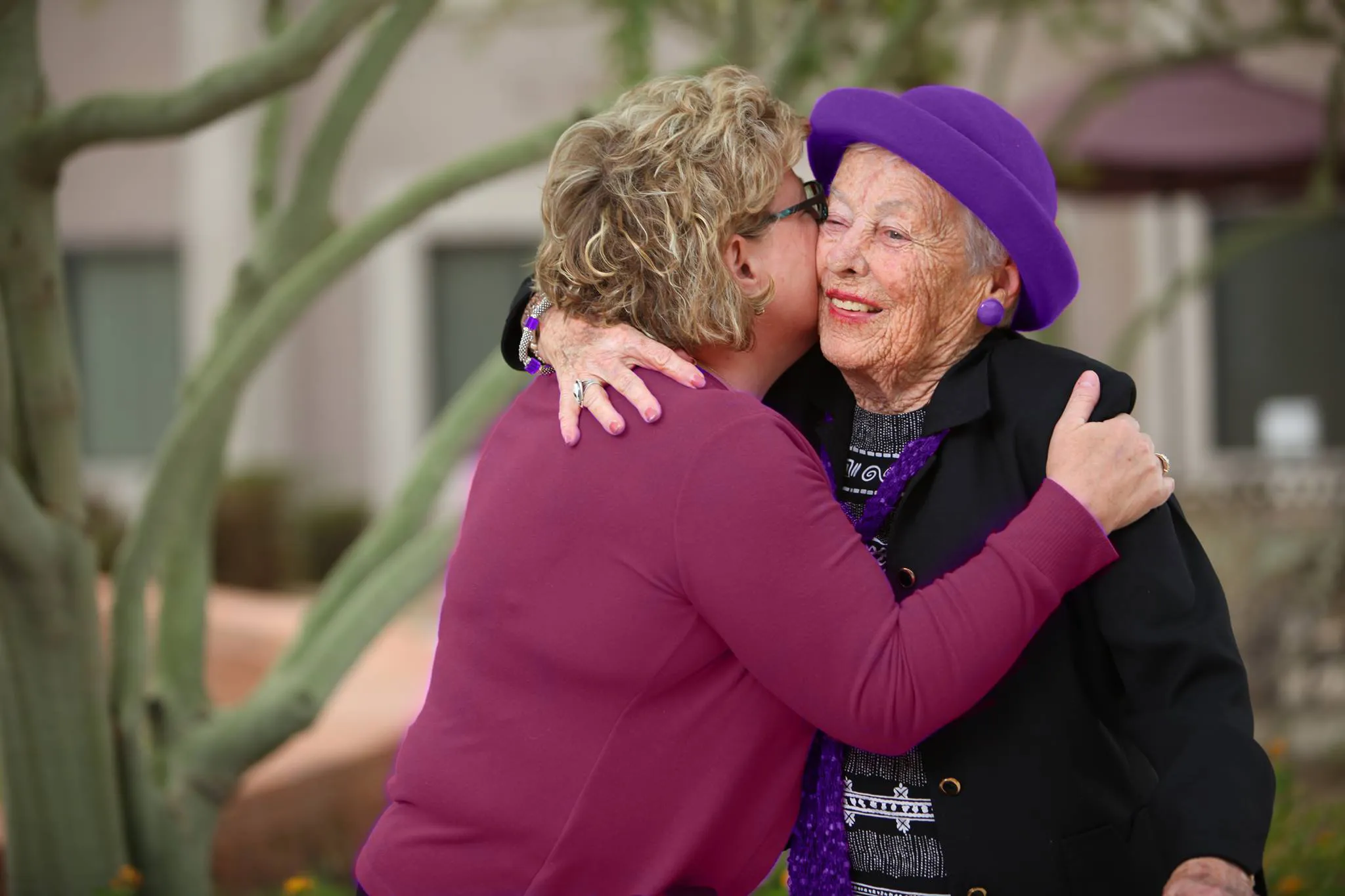 Woman Hugging Senior Resident at The Ivy Mckinney Senior Living TX Senior residents warmly hugging inside a bright senior living community in McKinney, TX at The Ivy of McKinney